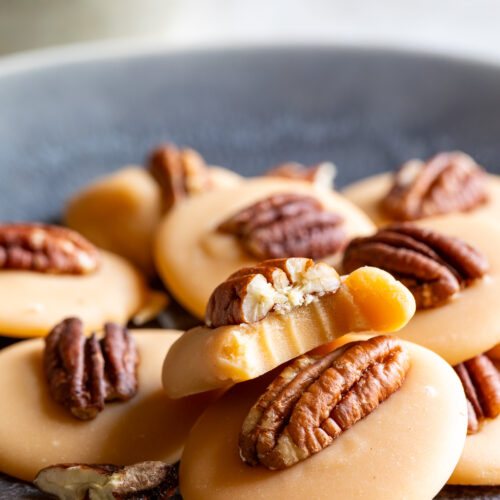 Leche quemada Mexican candy with pecans in the center, sitting on a plate.