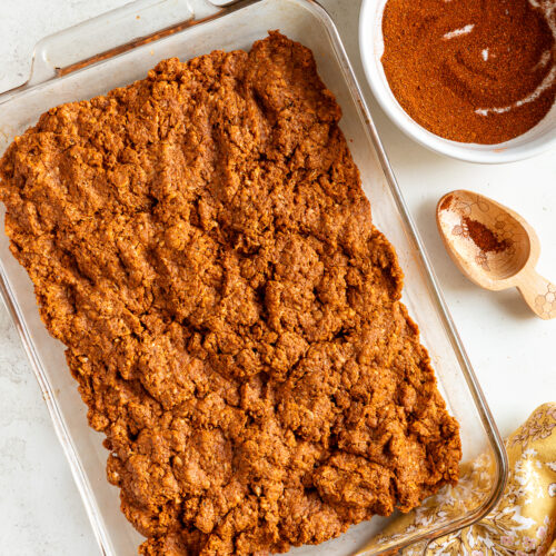 Mexican chorizo seasoned in a glass casserole dish, shown with chorizo spices.
