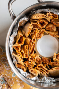 Tamales prepared to steam in a large stock pot.